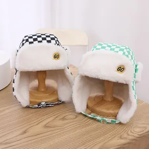 Detail der Kinder-Fliegermütze mit Karomuster, GO-Stickerei und Plüsch-Kunstfellfutter