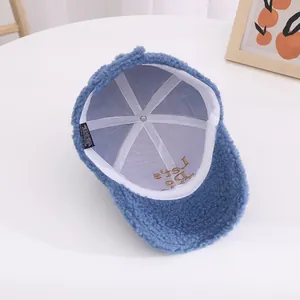 Detailed view of blue polar fleece cap lining with gold Let's Do embroidery