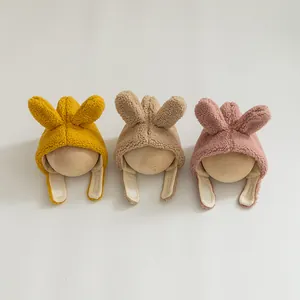 Detailansicht der Plüsch-Hasenohren-Babymützen in Gelb, Braun und Rosa aus Lammwolle