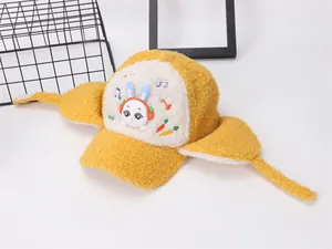 Detail of yellow sherpa fleece winter earflap hat with cute rabbit embroidery and earflaps