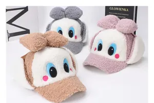 Vue détaillée de bonnets d'hiver en peluche pour enfants avec yeux de dessin animé et nœuds doux