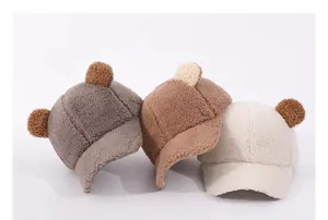 Detailed view of plush lamb wool baby baseball caps in grey, caramel, and cream colors