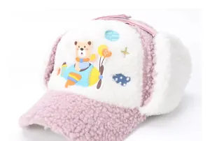 Detail of pink fleece aviator hat featuring cartoon bear and blue airplane embroidery
