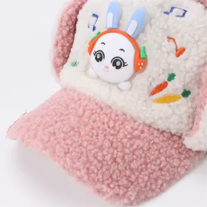 Detail of plush fleece kids winter hat featuring a 3D rabbit with ear muffs and embroidery
