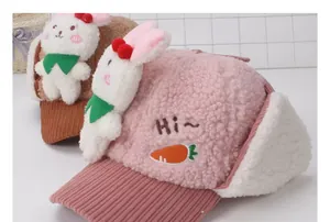 Detalle de orejas de conejo de peluche y bordado de zanahoria en gorros de invierno