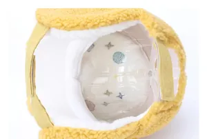 Detailed interior of plush yellow earflap hat showing star pattern lining and velcro