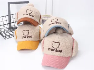 Detalle de gorros de aviador de sherpa para niños con bordado de oso y viseras de colores