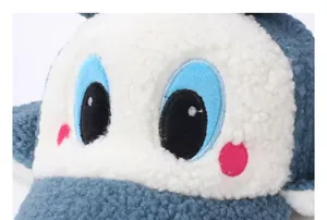 Gros plan détaillé sur un tissu en peluche doux avec broderie d'œil bleu et joues roses