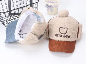 Detalle de gorra infantil de invierno con pelo sintético beige y bordado de oso