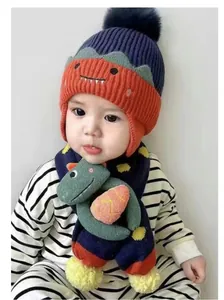 Detalle del conjunto de gorro y bufanda para bebé con muñeco dinosaurio 3D y orejeras