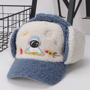 Close-up of winter child aviator hat with astronaut embroidery and blue fleece texture