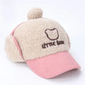Detalle del gorro de invierno para bebé de felpa sherpa con bordado de oso y ala de pana