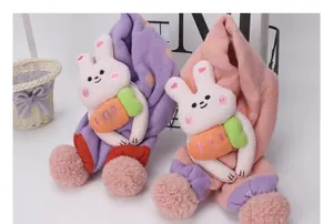 Detalle de bufandas de punto para niños con conejitos 3D y pompones suaves