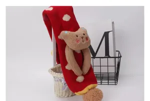 Detalle de bufanda de punto roja para bebé con lunares blancos y osito de peluche 3D
