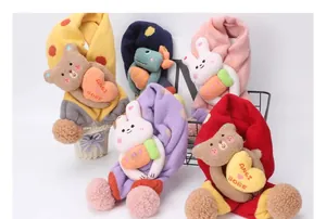 Detalle de bufandas de punto para bebé con peluches de animales y pompones suaves