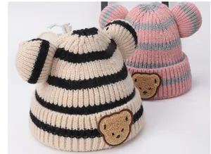 Dettaglio cappello neonato in maglia con orsetto, orecchie 3D e tessuto a righe pesanti