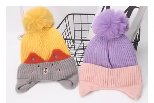 Detalle de gorros de punto para bebés con pompones y bordado de animales lindos