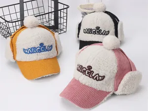 Detalle de gorros de invierno cálidos con pompones y orejeras de pana suave