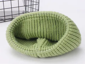 Dettaglio del berretto in maglia verde matcha con motivo a coste e tessuto morbido