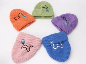 Dettaglio di cinque berretti in maglia colorati con ricami di animali per bambini