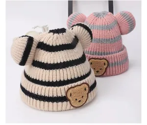 Dettaglio di berretti a righe per neonati con orecchie di orso e toppe di peluche