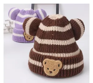Dettaglio dei cappelli a maglia a righe con orecchie di orso in viola e marrone scuro