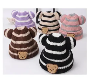Dettagli di cappelli neonato a maglia a righe colorate con orecchie di orso e toppe