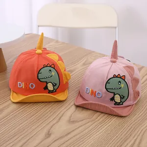 Detail of baby baseball caps featuring cartoon dinosaur embroidery and 3D fin decorations