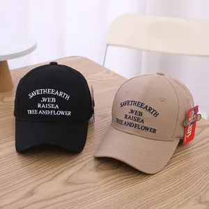 Schwarze und khakifarbene Baumwoll-Basecaps mit Save the Earth Stickerei auf Holzoberfläche