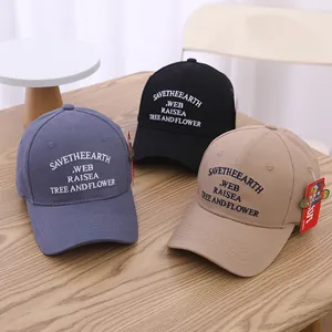 Drei bestickte Baumwoll-Baseballkappen in Graublau, Schwarz und Khaki auf Holztisch