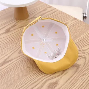 Détail d'une casquette jaune pour bébé avec broderie ours mignon et lettrage Bear