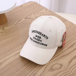 Detailansicht der beigen Baumwoll-Baseballkappe mit Save the Earth Stickerei auf Holztisch