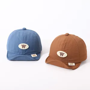 Detail of infant soft brim baseball caps with 'W' leather patch in blue and brown colors