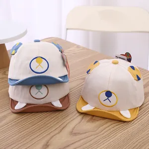 Detailed display of baby baseball caps with cartoon bear ears in blue, brown, and yellow