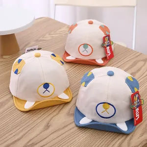 Detailed view of three baby baseball caps with bear ears and cute facial embroidery