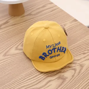 Detail of yellow cotton baby baseball cap with blue My Little Brother George embroidery