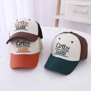 Close-up of three kids baseball caps with retro Colby Clark Country embroidery on a table