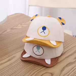 Detail of baby baseball caps featuring cartoon bear faces and 3D decorative horns