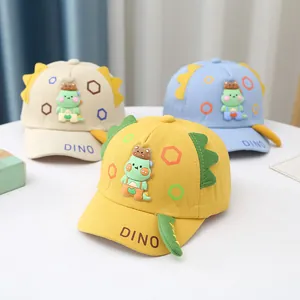 Detail of cartoon dinosaur baseball caps in yellow, beige, and blue with 3D accents