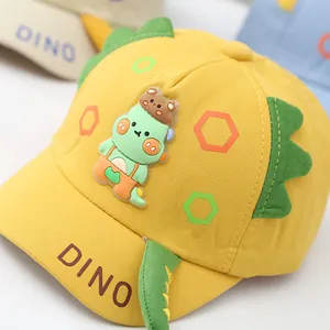 Detail of yellow toddler baseball cap with 3D green dinosaur spines and DINO text
