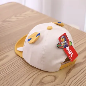 Detail of baby baseball cap with cute bear ears and wing accents on wooden background