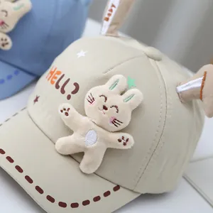 Close-up of baby baseball cap with plush rabbit decor and embroidered HELL lettering