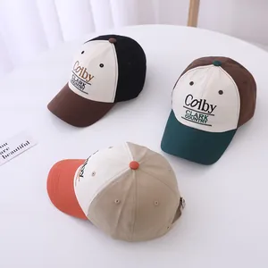 Detailed shot of three cotton baseball caps with letter embroidery and contrast color design