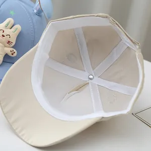 Detailed interior view of baby baseball cap showing white reinforced stitching and metal button