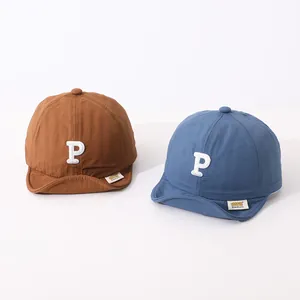 Detail view of quick-dry cotton kids baseball caps with embroidered P letter in brown and blue