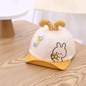 Détail de la broderie lapin et lettres sur la casquette souple pour bébé bicolore