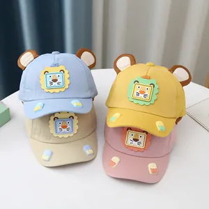 Dettaglio di quattro cappellini da baseball per bambini con orecchie 3D e patch di leone