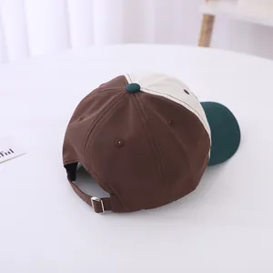 Detailed top view of a color-block baseball cap with adjustable metal buckle and embroidery