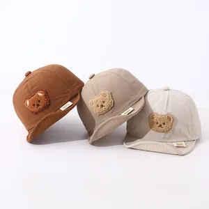 Detail of baby baseball caps showing soft brims and plush 3D bear patches in three colors