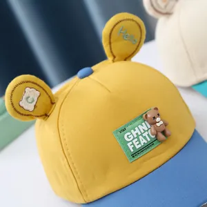Detail of yellow and blue baby baseball cap with cute bear doll and 3D ear accents